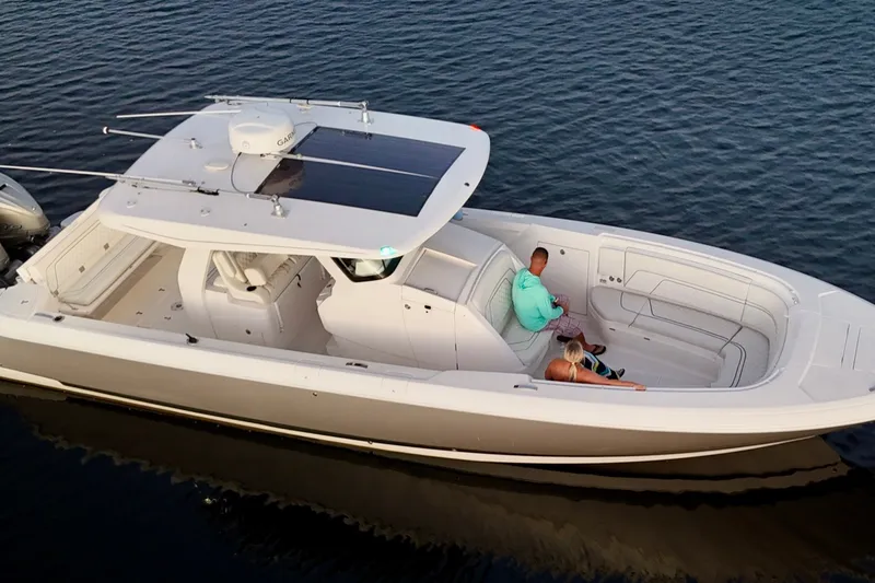 Slide: The Image of 2020 Intrepid 345 Nomad SE boat cruising with two passengers on calm water. - 8