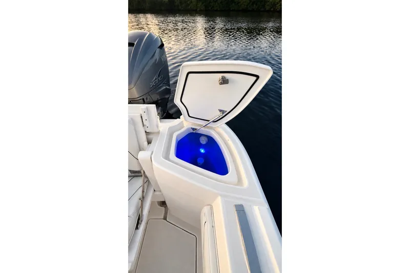 Slide: The Image of 2020 Intrepid 345 Nomad SE boat with open storage compartment and blue interior lighting. - 22