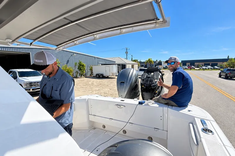 Slide: The Image of Two men working on a 2020 Intrepid 345 Nomad SE boat outdoors. - 46