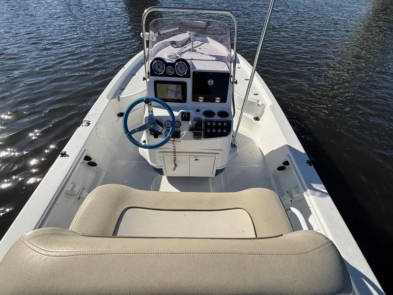 Slide: The Image of The image shows the cockpit of a 2022 NauticStar 215 XTS boat on the water. - 10