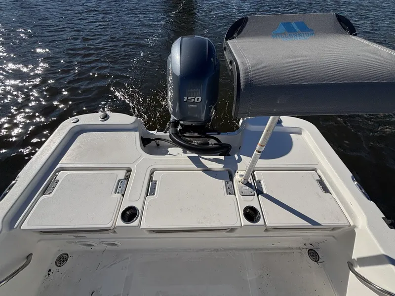 Slide: The Image of Aft view of a 2022 NauticStar 215 XTS with outboard motor on calm water. - 18