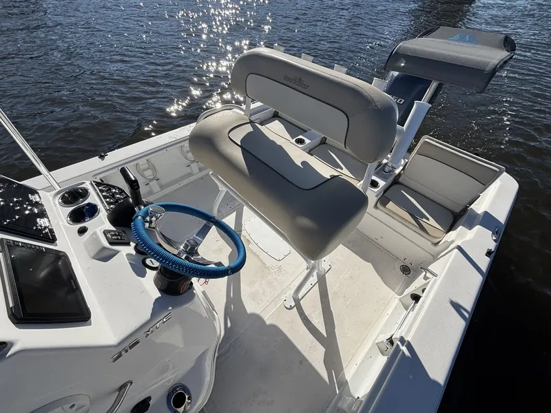 Slide: The Image of The image shows the cockpit of a 2022 NauticStar 215 XTS boat with a blue steering wheel. - 16
