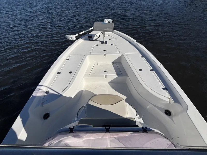 Slide: The Image of The image shows the deck of a 2022 NauticStar 215 XTS boat on calm water. - 12
