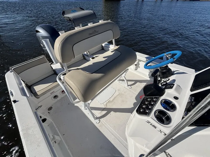 Slide: The Image of The image shows the cockpit of a 2022 NauticStar 215 XTS boat with beige seating. - 15