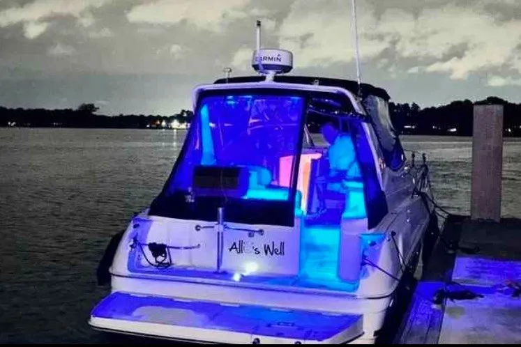 Slide: The Image of A 2000 Regal Commodore 2960 boat docked at night with vibrant blue interior lighting. - 1