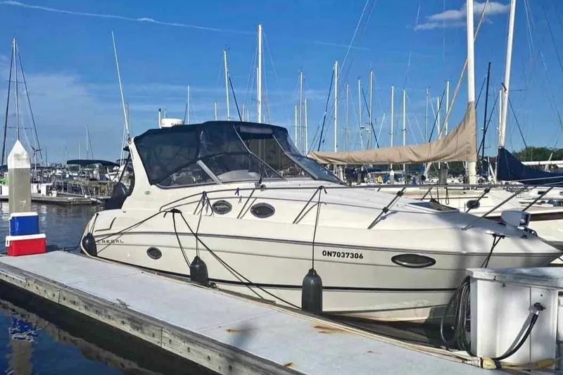The Image of 2000 Regal Commodore 2960 boat docked at marina with sailboats in background. - 0