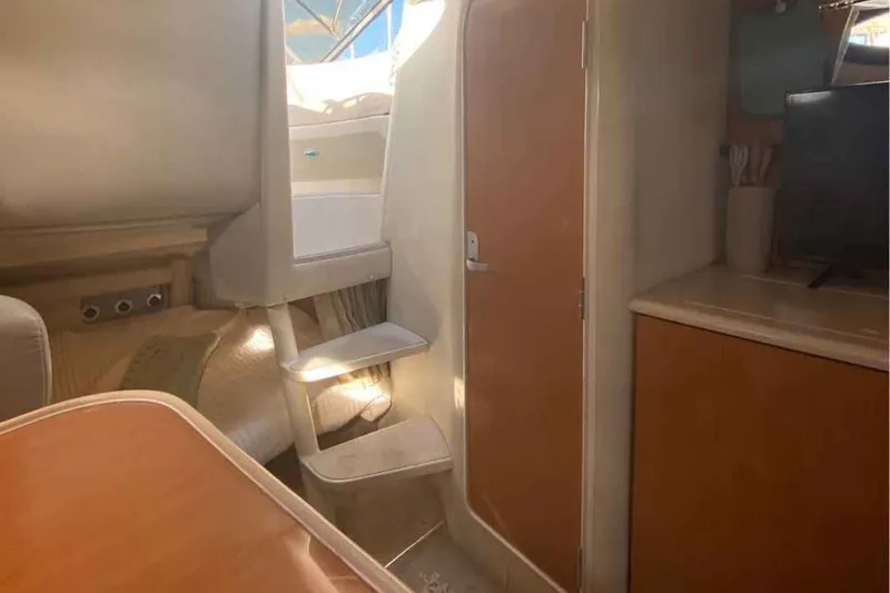 Slide: The Image of Interior of 2000 Regal Commodore 2960 boat, featuring stairs and wooden cabinetry. - 5