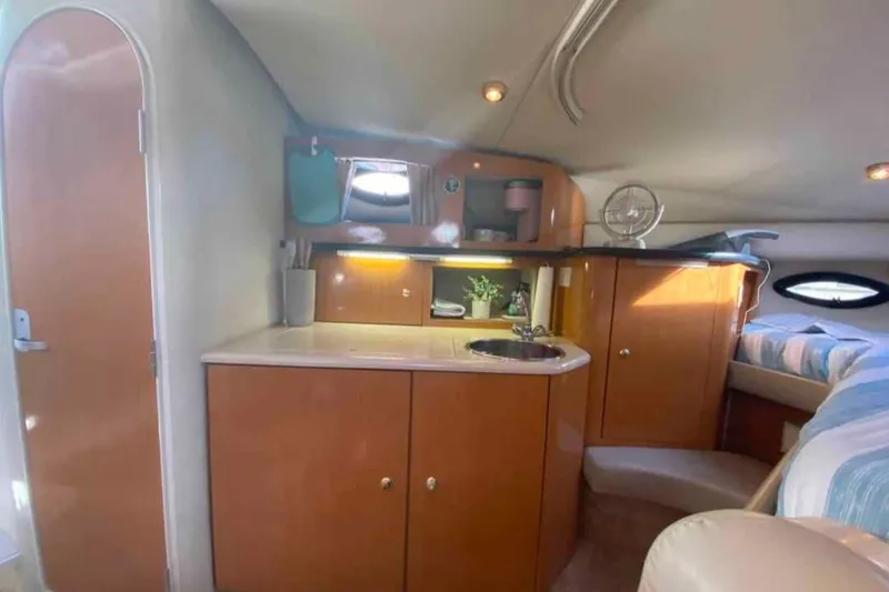 Slide: The Image of Interior of 2000 Regal Commodore 2960 boat with kitchenette and cozy sleeping area. - 4