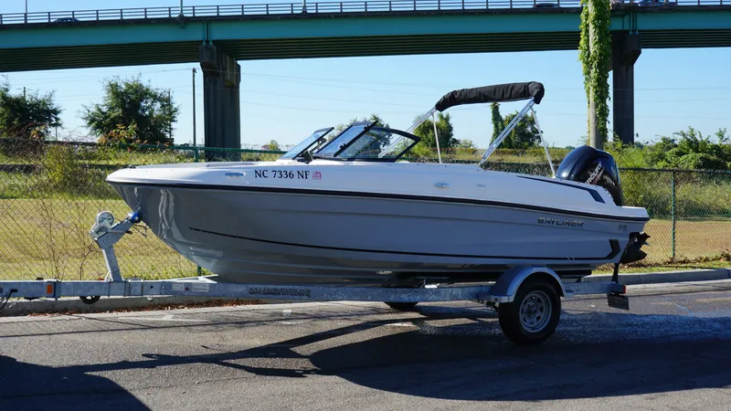 The Image of A 2025 Bayliner VR4 Bowrider OB on a trailer, parked next to a fence. - 0