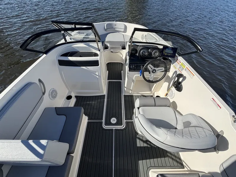 Slide: The Image of Bayliner VR4 Bowrider OB 2025: Spacious cockpit with gray seating and modern helm. - 10