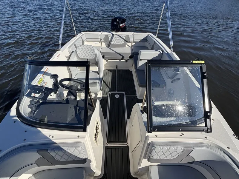Slide: The Image of Bayliner VR4 Bowrider OB 2025: Modern bowrider with comfortable seating and clear windshield on calm water. - 19