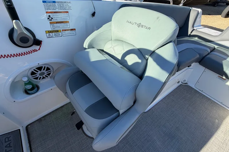 Slide: The Image of 2024 NauticStar 223 DC Deck boat interior with cushioned seating and control panel. - 12