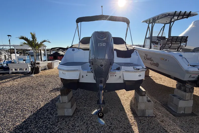 Slide: The Image of 2024 NauticStar 223 DC Deck boat with Yamaha 150 engine, displayed outdoors. - 5