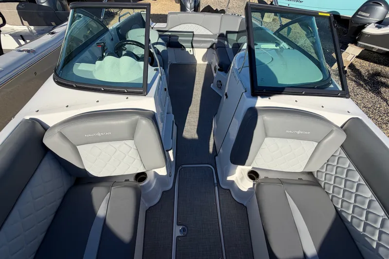 Slide: The Image of 2024 NauticStar 223 DC Deck boat interior with gray seating and dual consoles. - 21