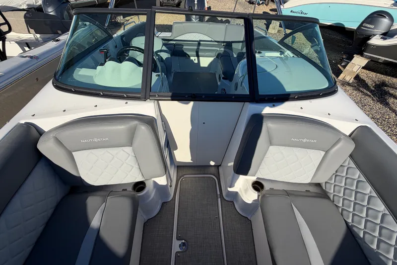 Slide: The Image of 2024 NauticStar 223 DC Deck boat interior with gray seating and windshield. - 22