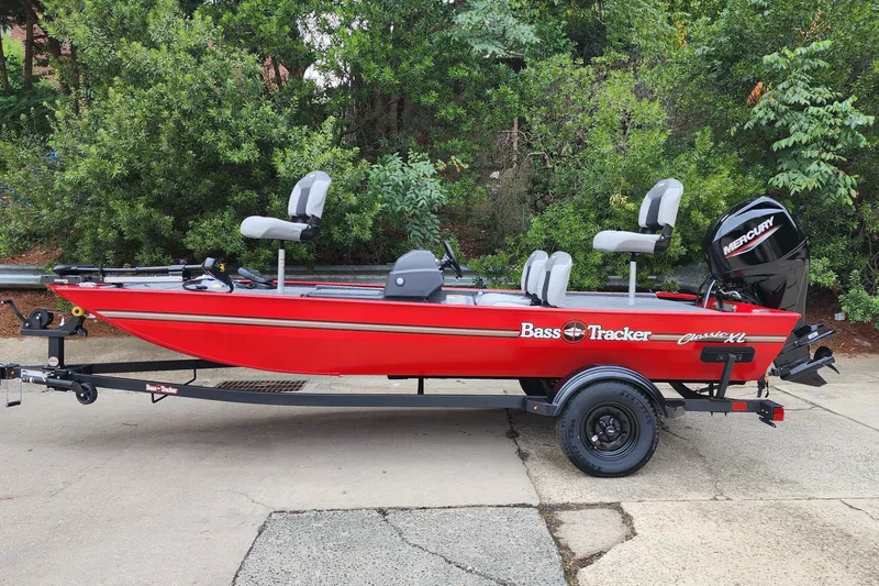The Image of Red 2027 Tracker Bass Tracker Classic XL boat on trailer, parked outdoors. - 0