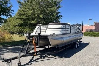 Slide: The Image of 2024 Palm Beach 23 HPT pontoon boat on trailer, parked outdoors. - 1