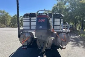 Slide: The Image of 2024 Palm Beach 23 HPT pontoon boat with powerful outboard motor, parked outdoors. - 9
