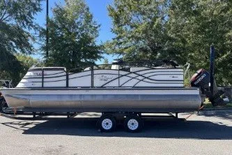The Image of 2024 Palm Beach 23 HPT pontoon boat on trailer, parked outdoors. - 0