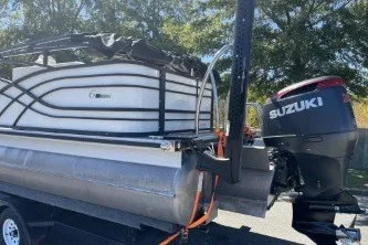 Slide: The Image of 2024 Palm Beach 23 HPT pontoon boat with Suzuki outboard motor on trailer. - 8