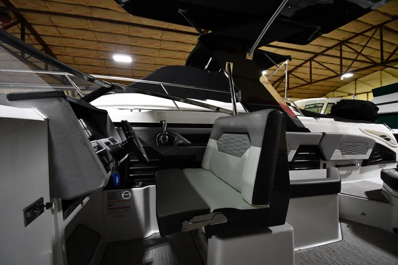 Slide: The Image of 2024 Cobalt A29 boat interior with modern seating and steering wheel in a showroom. - 13