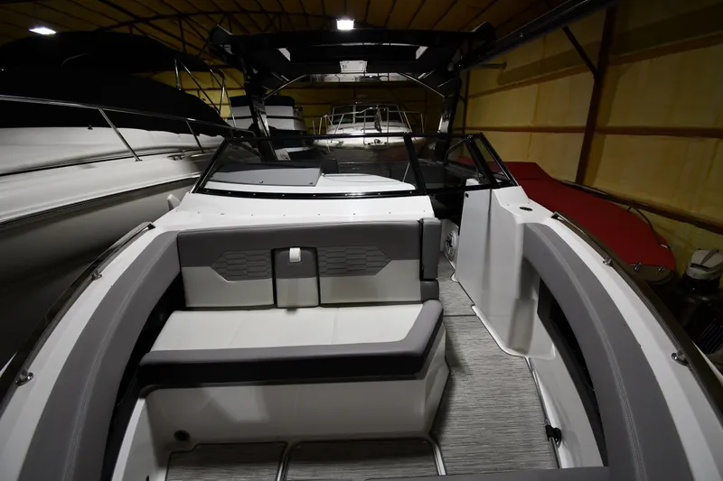 Slide: The Image of 2024 Cobalt A29 boat interior with sleek seating and modern design in a dimly lit showroom. - 6