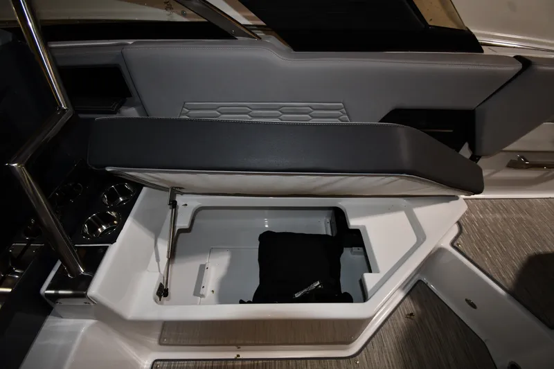 Slide: The Image of 2024 Cobalt A29 boat interior storage compartment with open seat and cup holders. - 19
