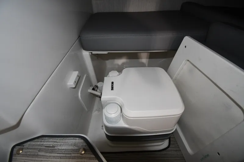 Slide: The Image of 2024 Cobalt A29 boat interior with compact marine toilet and seating area. - 30