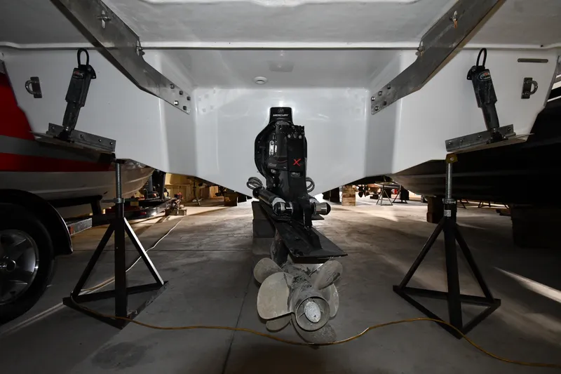 Slide: The Image of 2024 Cobalt A29 boat stern with propeller and outdrive in a garage setting. - 35