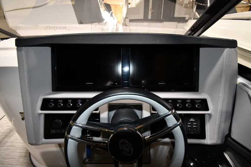 Slide: The Image of 2024 Cobalt A29 boat dashboard with dual Garmin displays and steering wheel. - 10