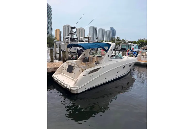 Slide: The Image of 2013 Sea Ray Sundancer 310 docked at marina with city skyline backdrop. - 2