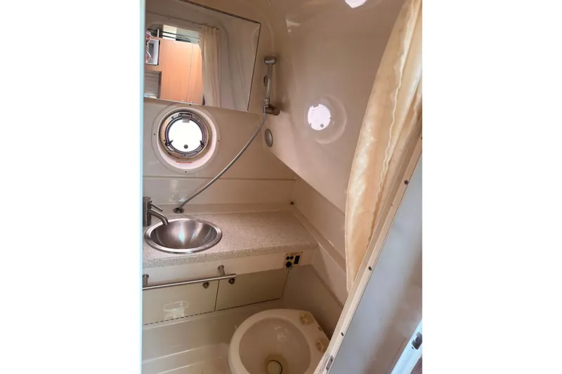 Slide: The Image of 2013 Sea Ray Sundancer 310 bathroom with sink, porthole, and shower area. - 10