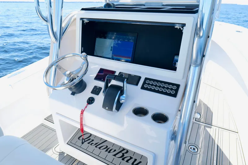 Slide: The Image of 2024 Onslow Bay 27 Offshore Edition boat console with steering wheel and navigation display. - 14