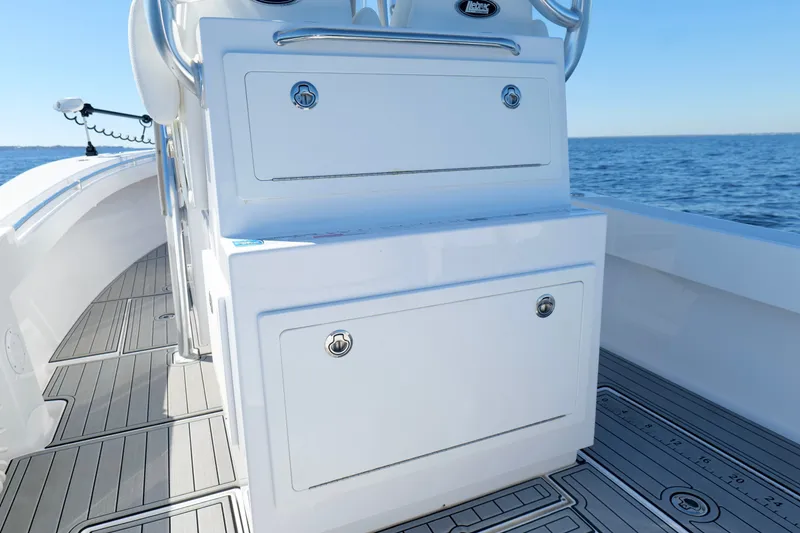 Slide: The Image of 2024 Onslow Bay 27 Offshore Edition boat interior with storage compartments, on calm ocean water. - 22