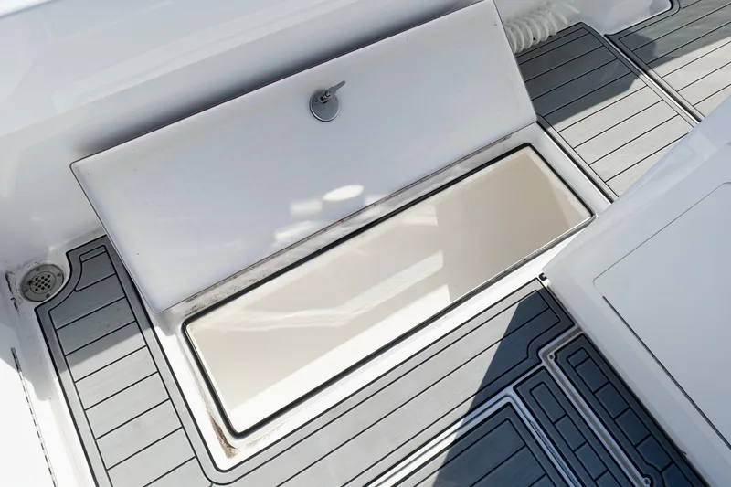 Slide: The Image of 2024 Onslow Bay 27 Offshore Edition boat deck with storage compartment open. - 30