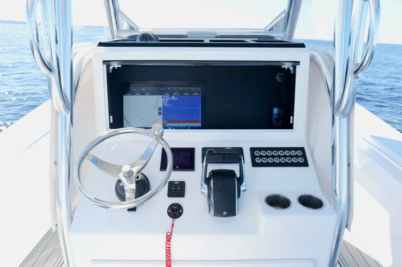 Slide: The Image of 2024 Onslow Bay 27 Offshore Edition boat console with steering wheel and navigation display. - 13