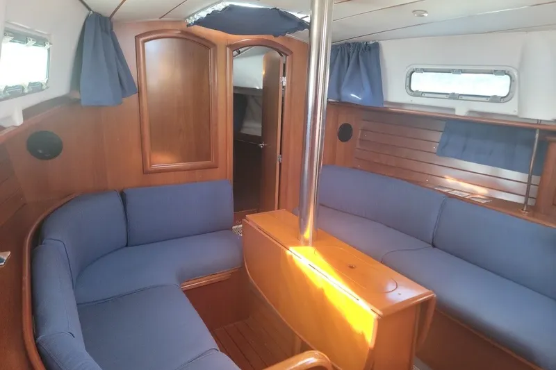 Slide: The Image of Interior of 2001 Beneteau Oceanis Clipper 36 CC yacht with blue seating and wooden finishes. - 2