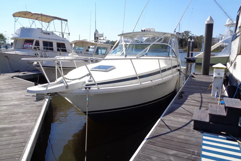Slide: The Image of 1994 Bertram 30 Moppie boat docked at marina, surrounded by other vessels. - 3
