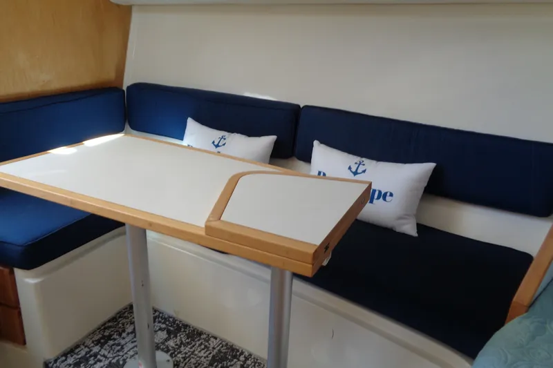 Slide: The Image of Interior of 1994 Bertram 30 Moppie with blue seating and nautical-themed pillows. - 29