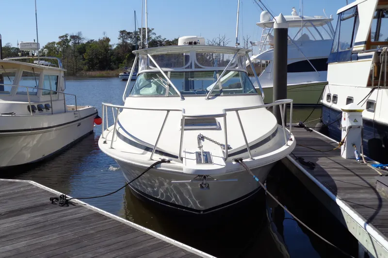 Slide: The Image of 1994 Bertram 30 Moppie boat docked at marina, surrounded by other vessels. - 2