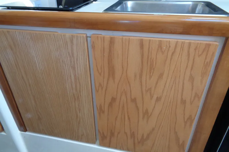 Slide: The Image of Wooden cabinetry and stainless steel sink in 1994 Bertram 30 Moppie boat interior. - 34