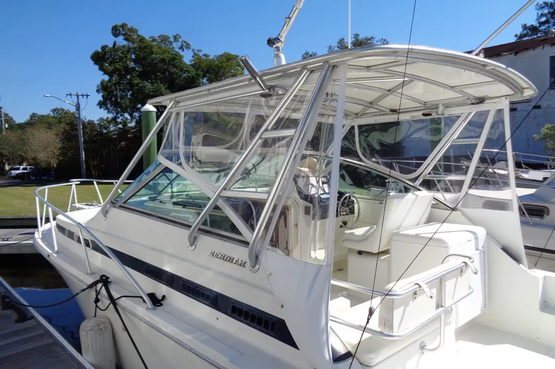 Slide: The Image of 1994 Bertram 30 Moppie boat docked, featuring sleek design and spacious cockpit area. - 6