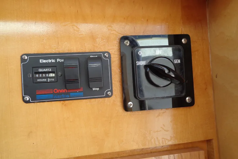 Slide: The Image of 1994 Bertram 30 Moppie electric power panel with Onan Marine controls and shore/gen switch. - 43