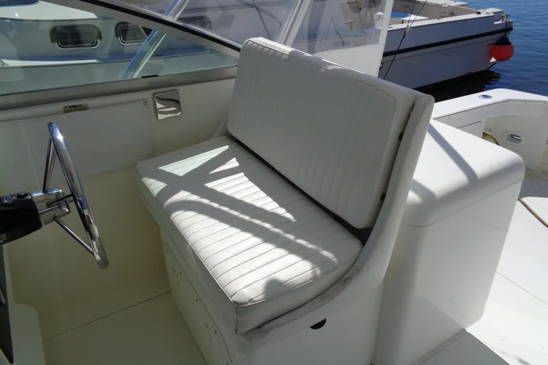 Slide: The Image of 1994 Bertram 30 Moppie boat interior with white seating and steering wheel. - 13