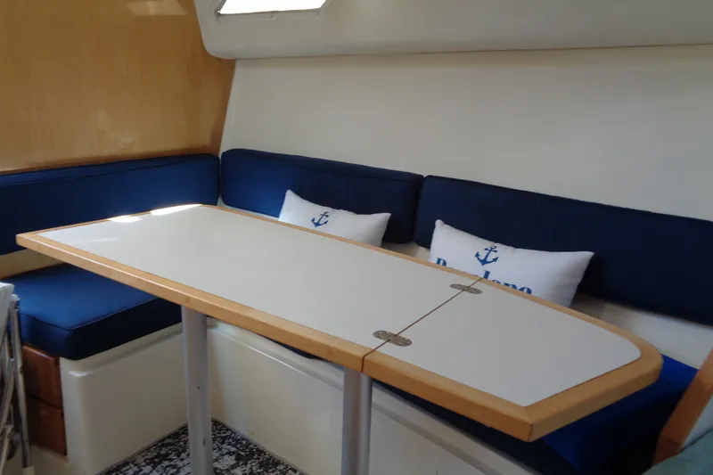 Slide: The Image of Interior of 1994 Bertram 30 Moppie with blue seating and white table. - 28