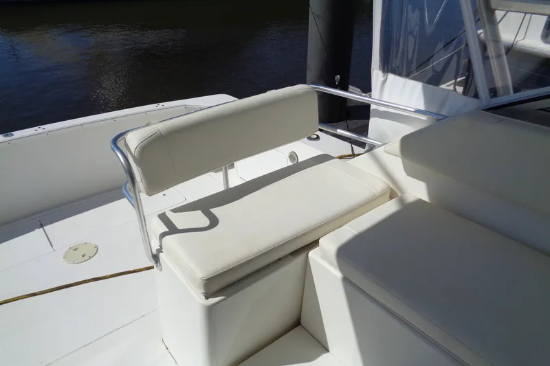 Slide: The Image of White seating area on a 1994 Bertram 30 Moppie boat, docked by the water. - 19