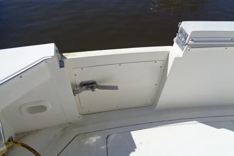 Slide: The Image of 1994 Bertram 30 Moppie boat deck with hatch and handle, near water. - 10