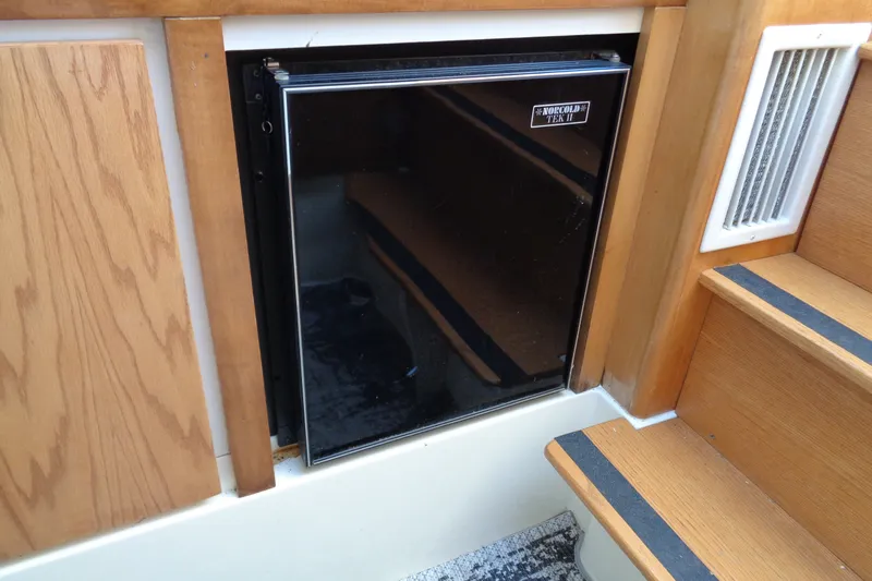 Slide: The Image of 1994 Bertram 30 Moppie interior with Norcold Tek II refrigerator and wooden cabinetry. - 33