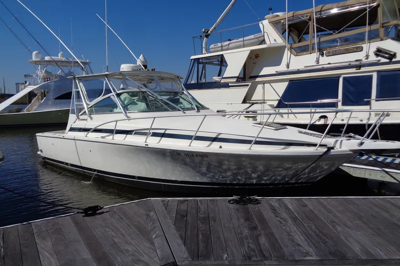 The Image of 1994 Bertram 30 Moppie boat docked at marina under clear blue sky. - 1