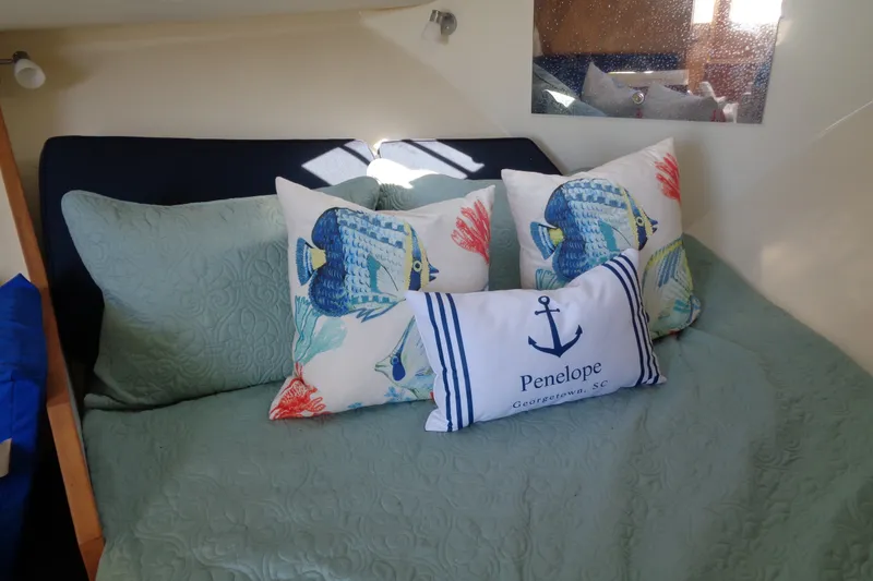 Slide: The Image of Cozy cabin interior of 1994 Bertram 30 Moppie with nautical-themed pillows. - 30
